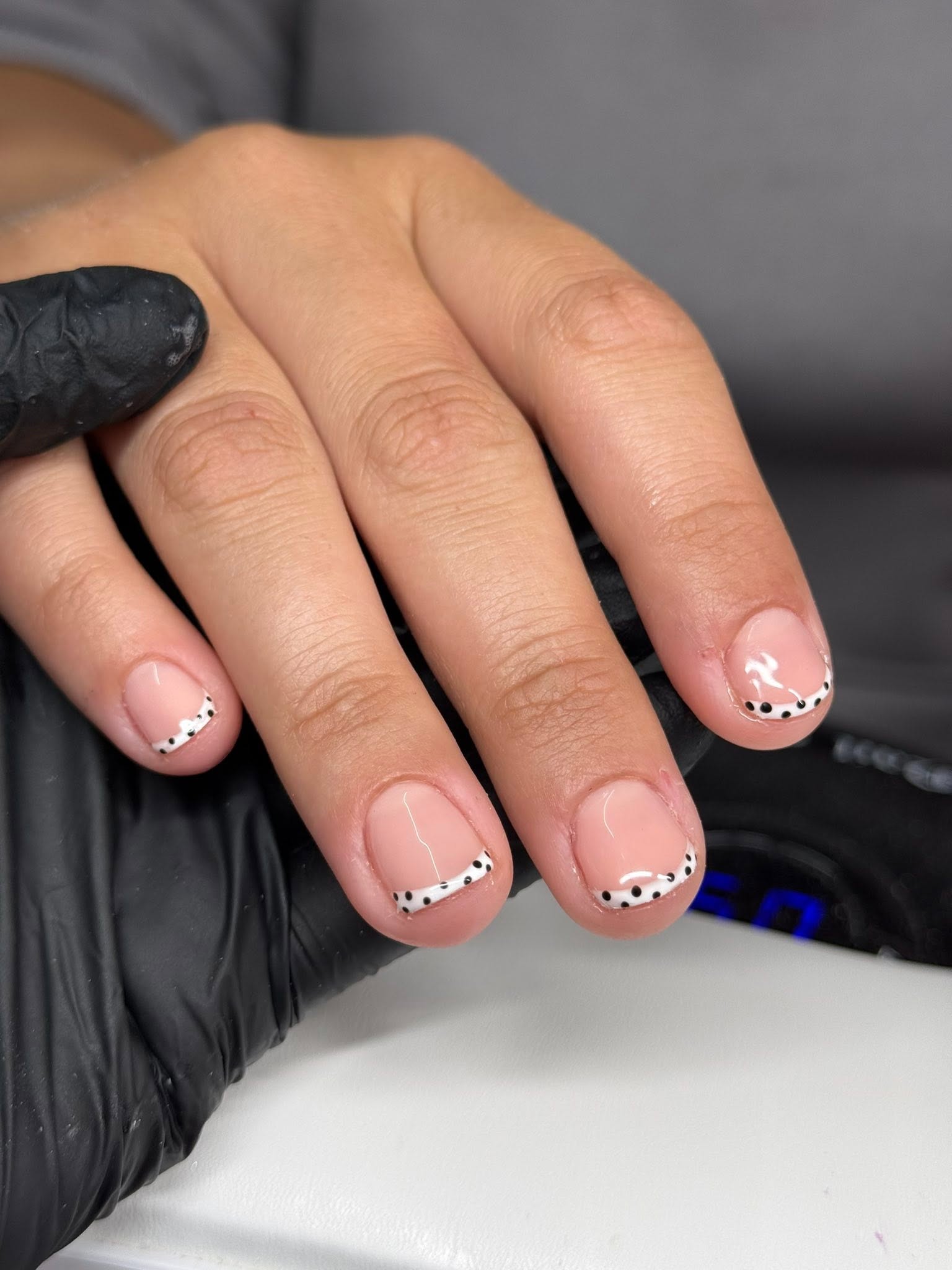 French tip nails with black polka dot detail